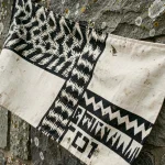 Drapeau breton Gwenn-ha-Du accroché sur un mur en granit d'un village côtier breton, détails des hermines et des bandes noires et blanches visibles