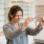 Femme de 45 ans essayant une paire de lunettes de lecture chez l'opticien