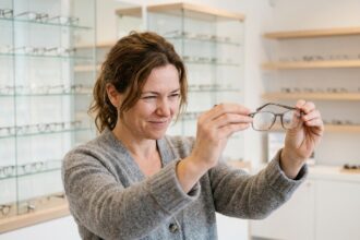 Femme de 45 ans essayant une paire de lunettes de lecture chez l'opticien