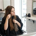 Femme en salon de coiffure comparant des extensions de cheveux à sa couleur naturelle