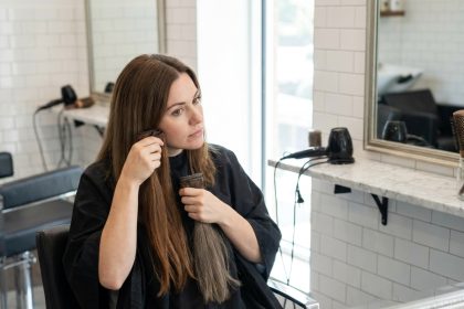 Femme en salon de coiffure comparant des extensions de cheveux à sa couleur naturelle