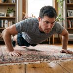 Homme en train de faire des pompes dans un salon cosy