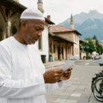 Homme consultant un horaire de prière devant une mosquée à Grenoble avec les montagnes en arrière-plan