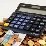 une calculatrice, des pièces de monnaie et des billets