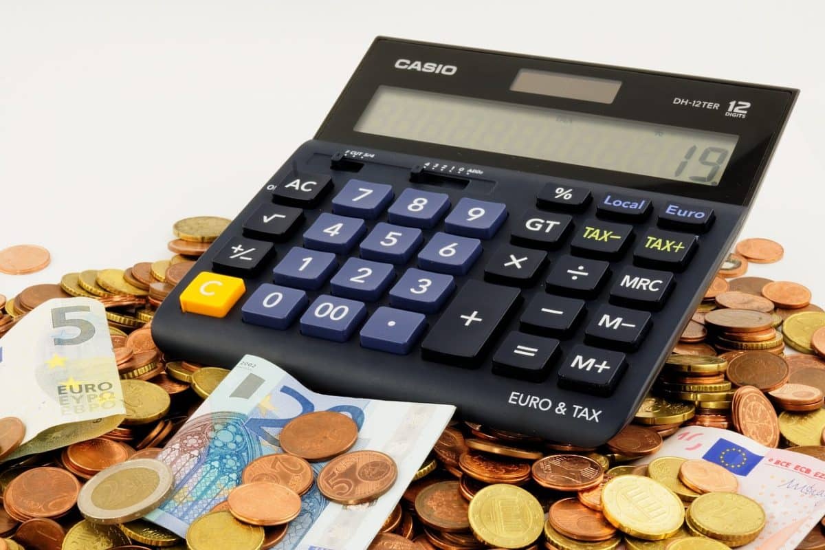 une calculatrice, des pièces de monnaie et des billets